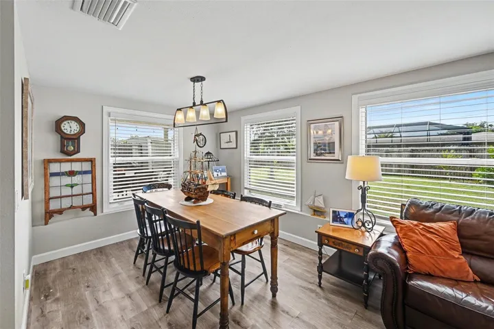 Dining area with large windows seamlessly integrated into the open floor plan at 412 Redwood Road, Venice, Florida