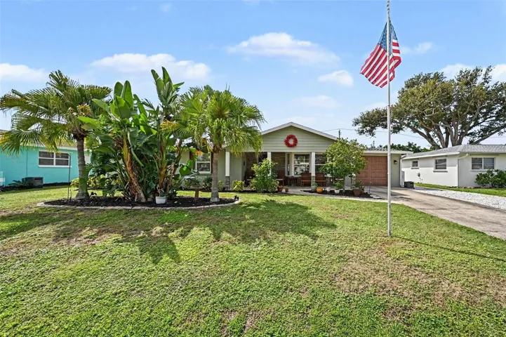 Daytime front elevation showing curb appeal and palm trees at 412 Redwood Road, Venice, Florida