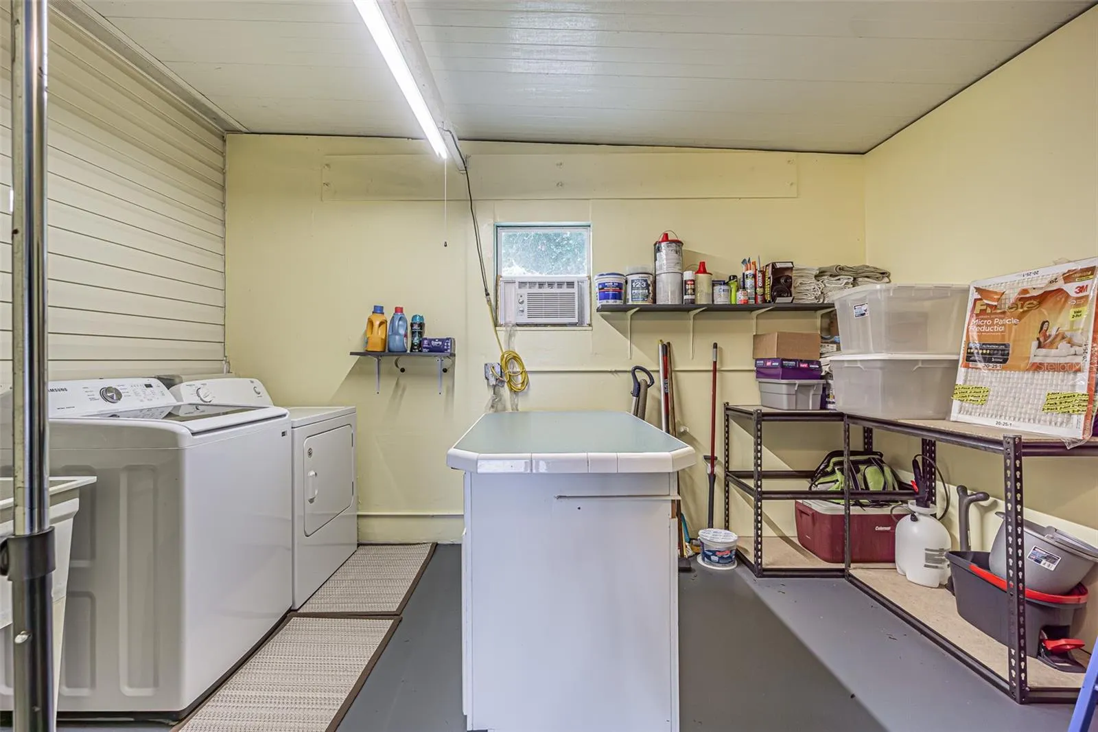 AWESOME laundry area with AC, utiltiy sink and folding center island for storage in shed