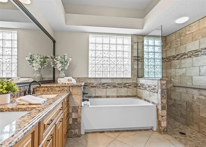 Primary Bathroom with tub and roman shower