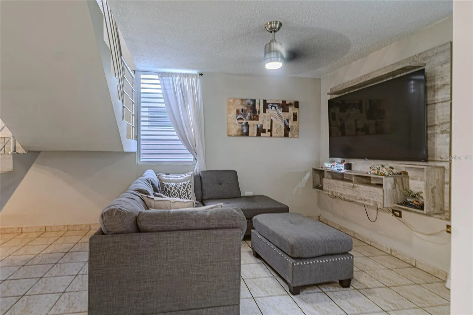 Family room with ceiling fan and built-in TV wall / Sala familiar con abanico de techo y panel de TV empotrado Family room with ceiling fan and built-in TV wall / Sala familiar con abanico de techo y panel de TV empotrado