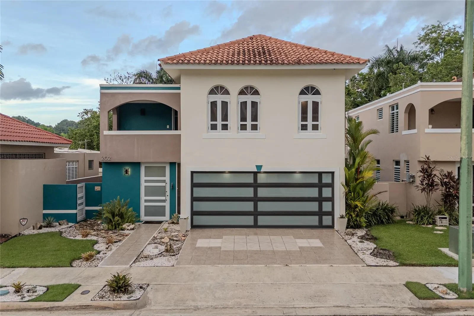 Modern two-story home with tile roof and glass garage door / Residencia moderna de dos niveles con techo de tejas y portón de cristal Modern two-story home with tile roof and glass garage door / Residencia moderna de dos niveles con techo de tejas y portón de cristal