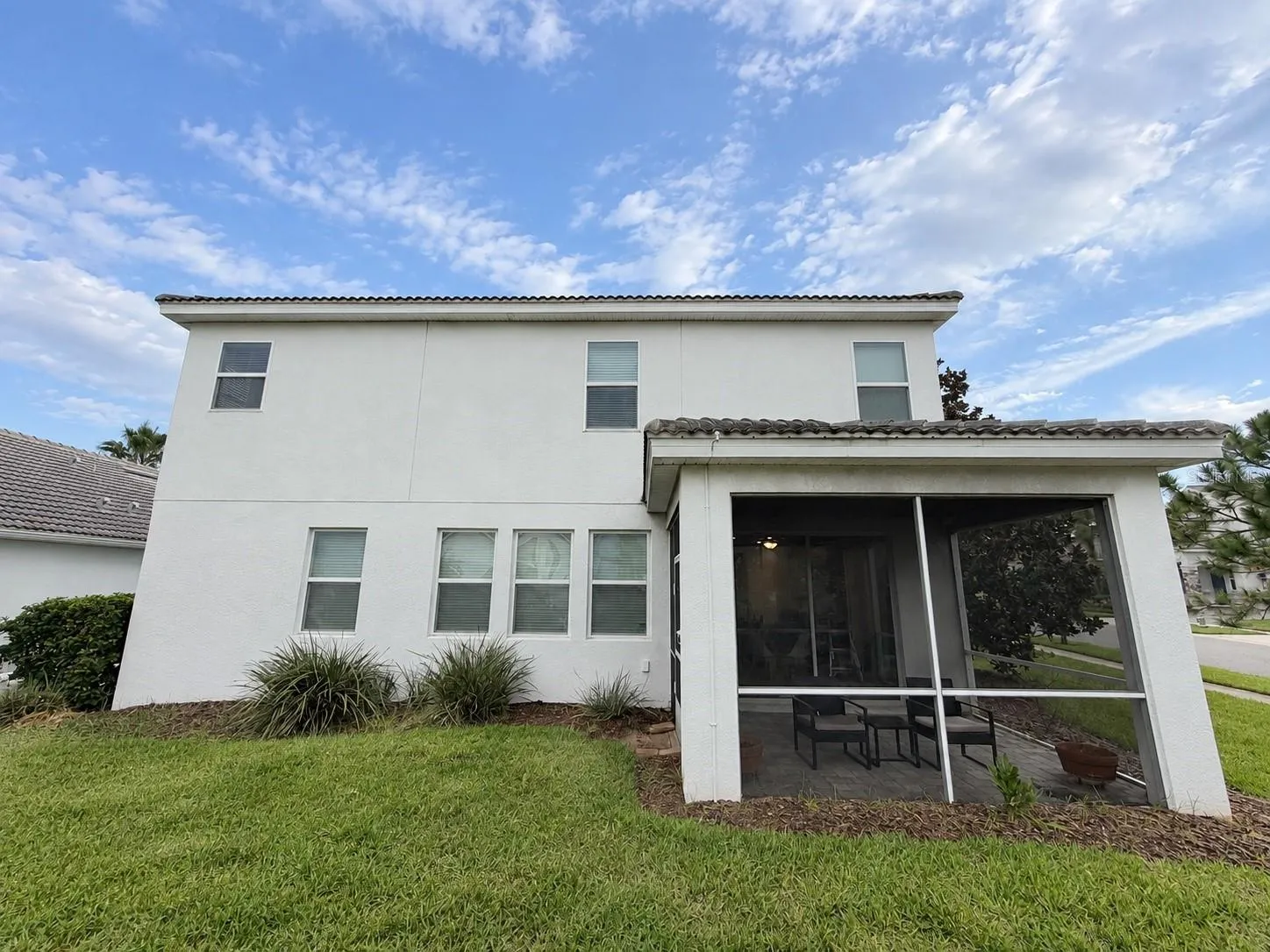 Rear exterior showcases the home's spacious footprint and private screened outdoor living area.
