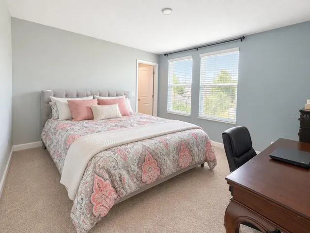 Comfortable fourth bedroom with excellent natural light and closet storage.
