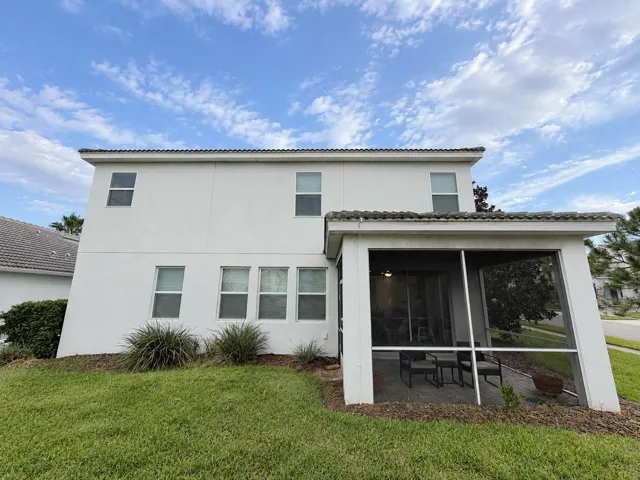 Rear exterior showcases the home's spacious footprint and private screened outdoor living area.