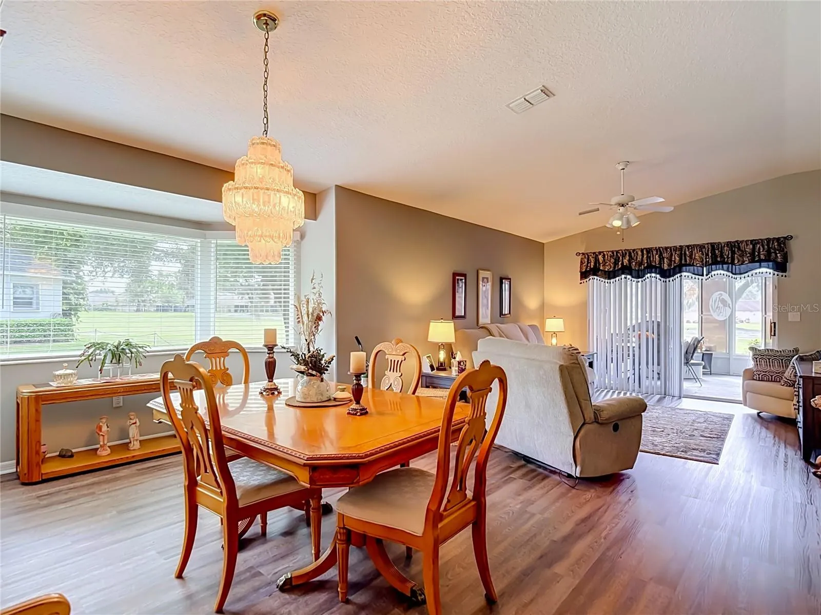 The dining area sits on luxury vinyl flooring . The bay windrow gives you a view of the 10th fairway.
