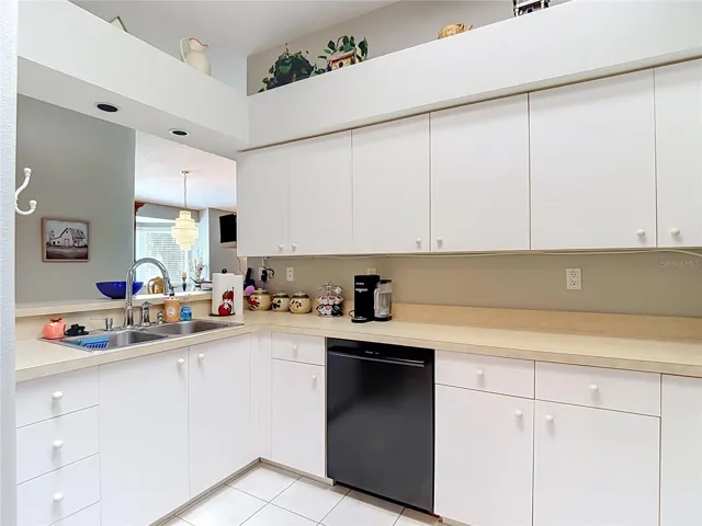 Double sink with newer faucet. There are decorative shelves above the cabinets for your collectibles, plants etc.