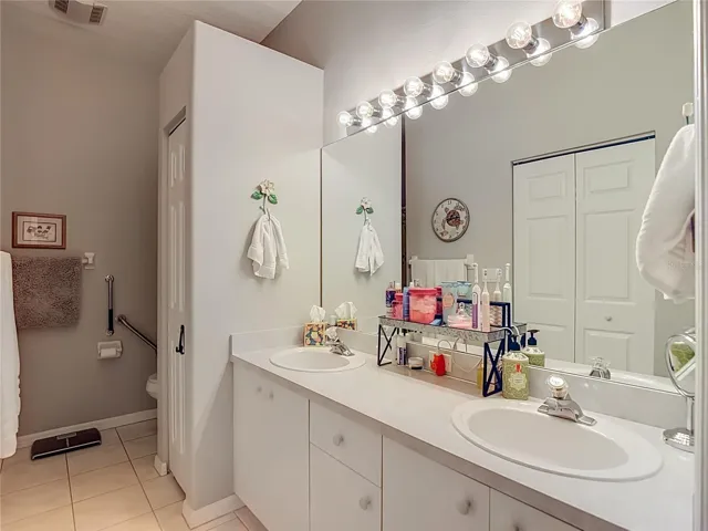 The primary bathroom has double sinks with a large mirror and linen closet for your bathing needs.