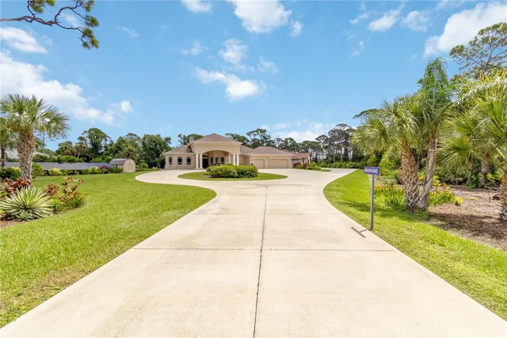 Entrance to the 4.6 acre property. The entire driveway is concrete with parking for about 15 cars. The solar panels are to the left. The panels are owned free and clear.