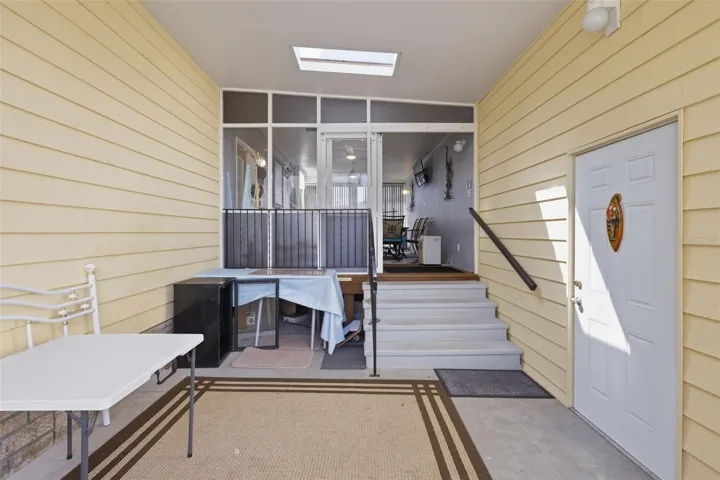 Entrance of home from right side. Door at right leads to garage/workshop. Stairs lead to large Florida Room.