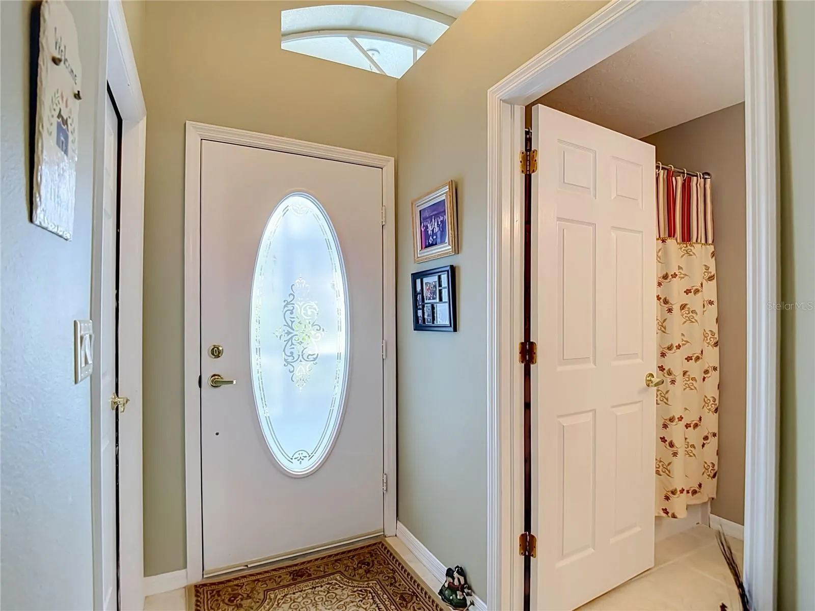 As you enter the open door is to bathroom 2. To the right is the door out to the garage.