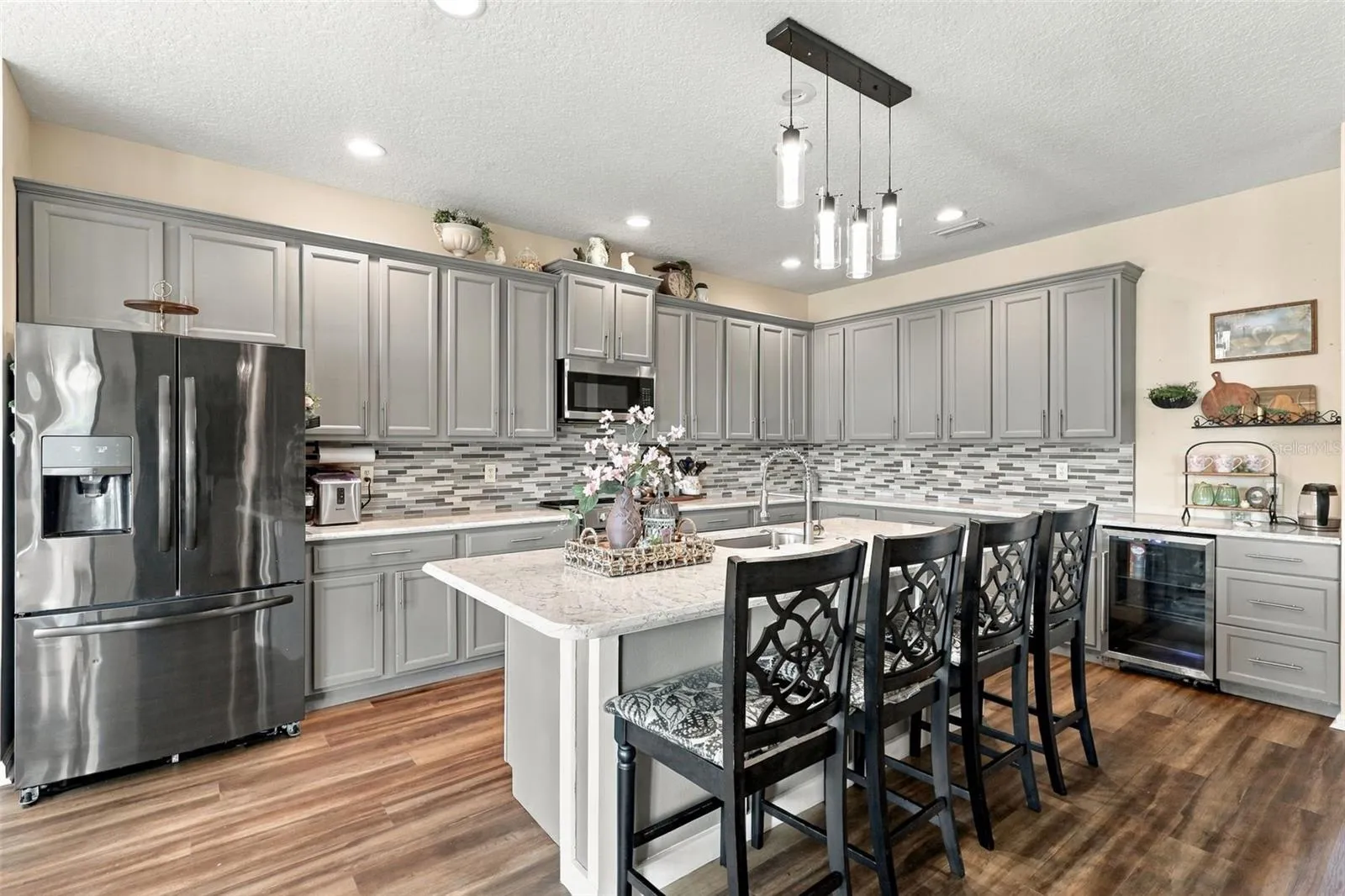 Look at this gorgeous updated kitchen with custom tile backsplash and quartz countertops.