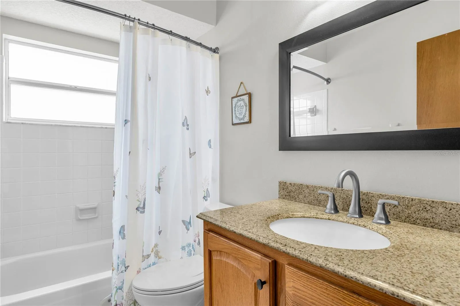 hall bathroom with granite counter top and new, modern ceramic tile flooring