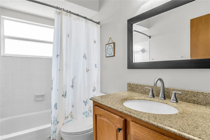 hall bathroom with granite counter top and new, modern ceramic tile flooring