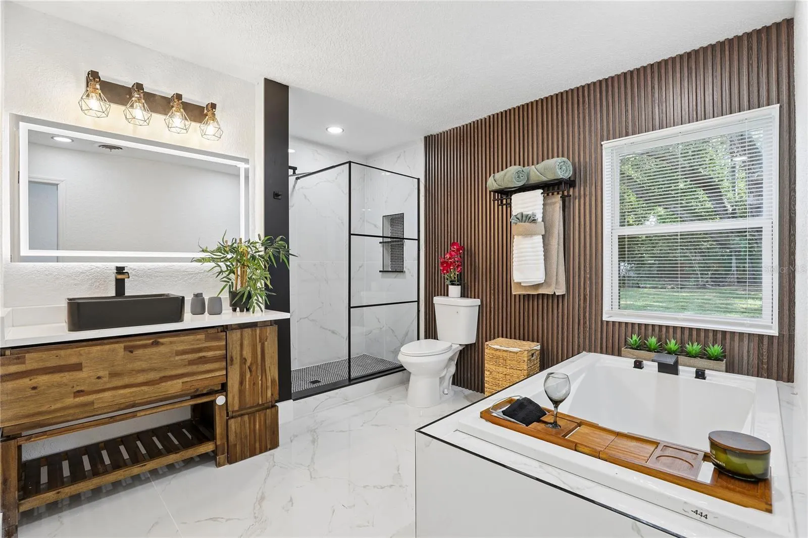 Spa-inspired primary bath with soaking tub and custom wood accent wall