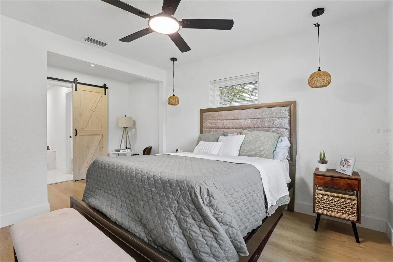 Primary suite with decorative wood details, barn door and modern lighting