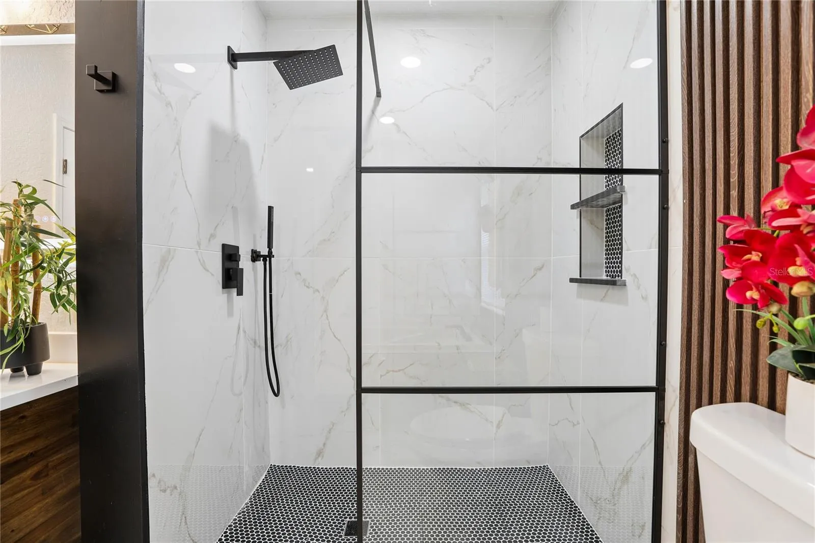 Separate glass-enclosed walk-in shower with rainfall showerhead