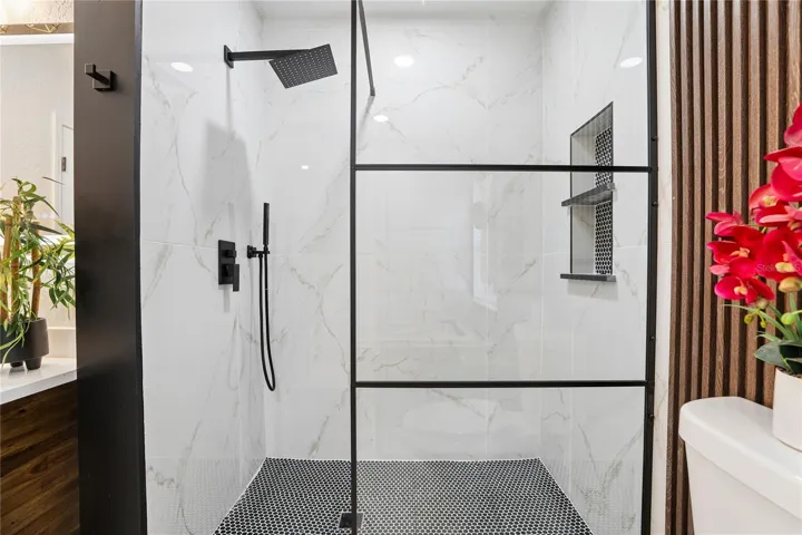 Separate glass-enclosed walk-in shower with rainfall showerhead