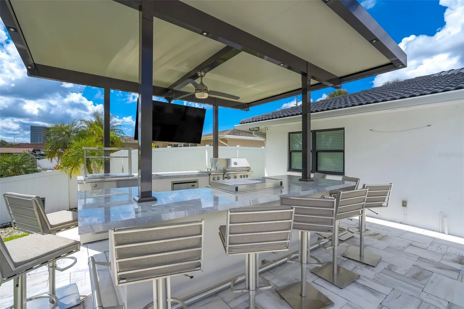 Outdoor kitchen with gas grill, griddle, multiple beverage coolers, and speaker system
