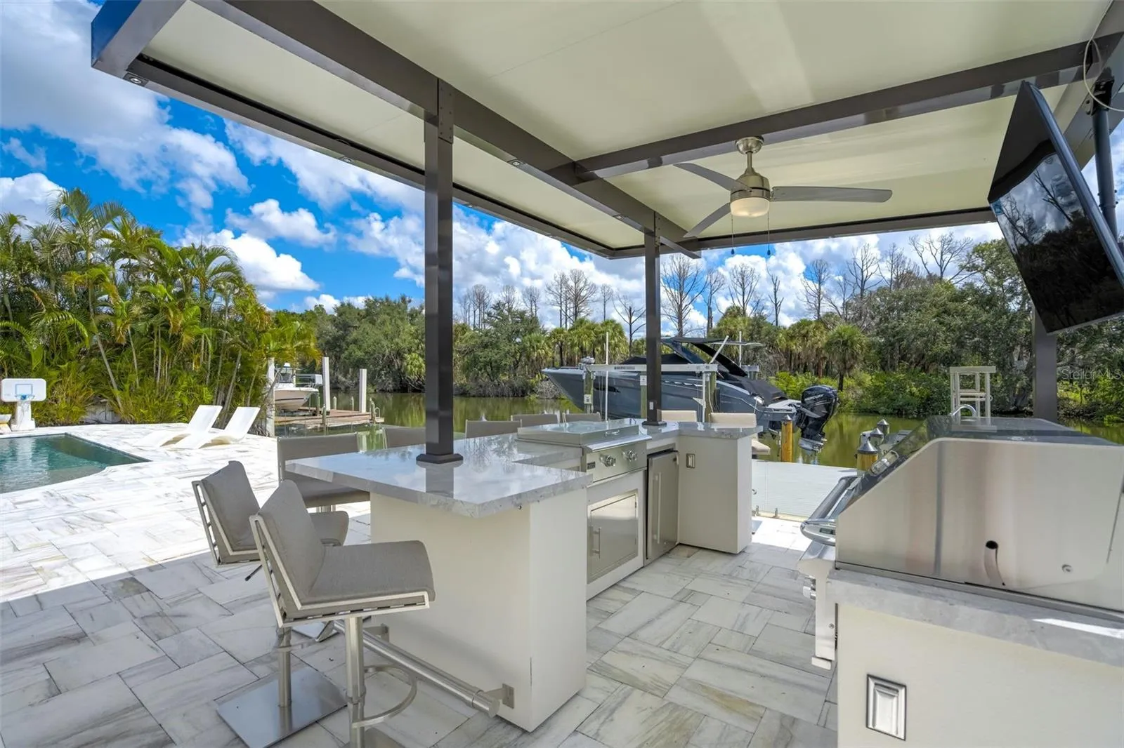 Outdoor kitchen with gas grill, griddle, multiple beverage coolers, and speaker system
