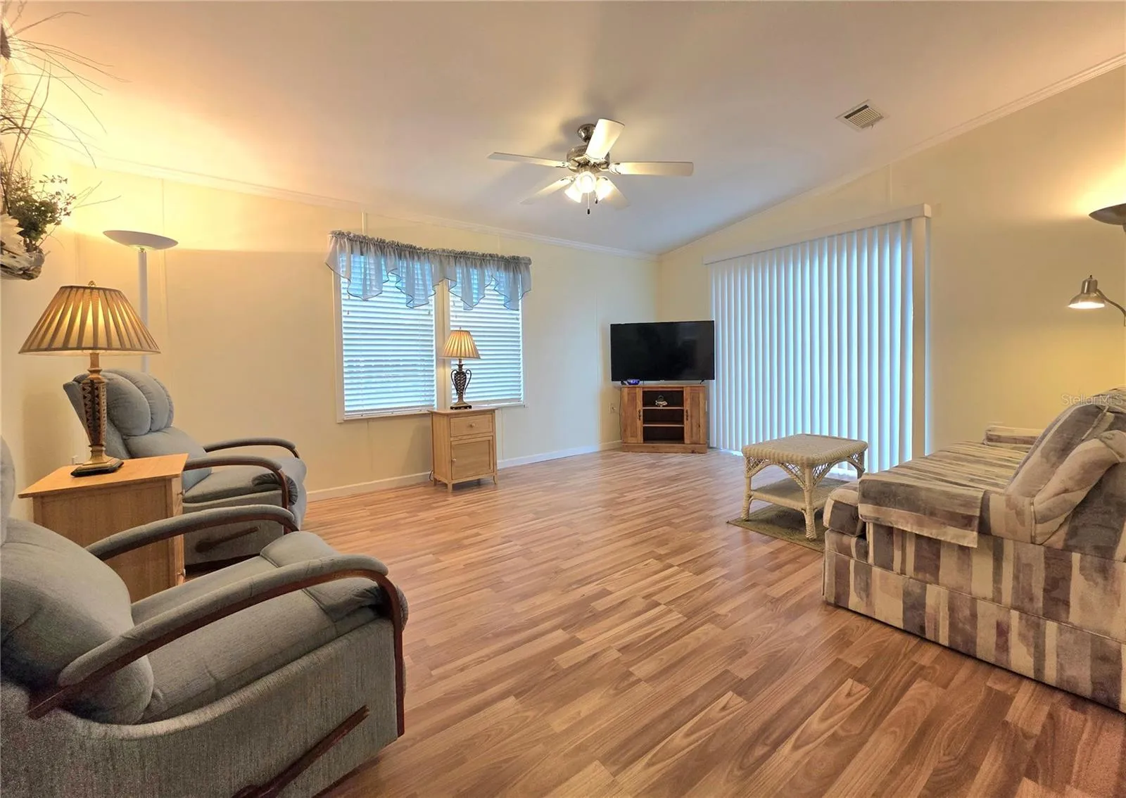 Spacious living room with sliding glass door to the front of home.