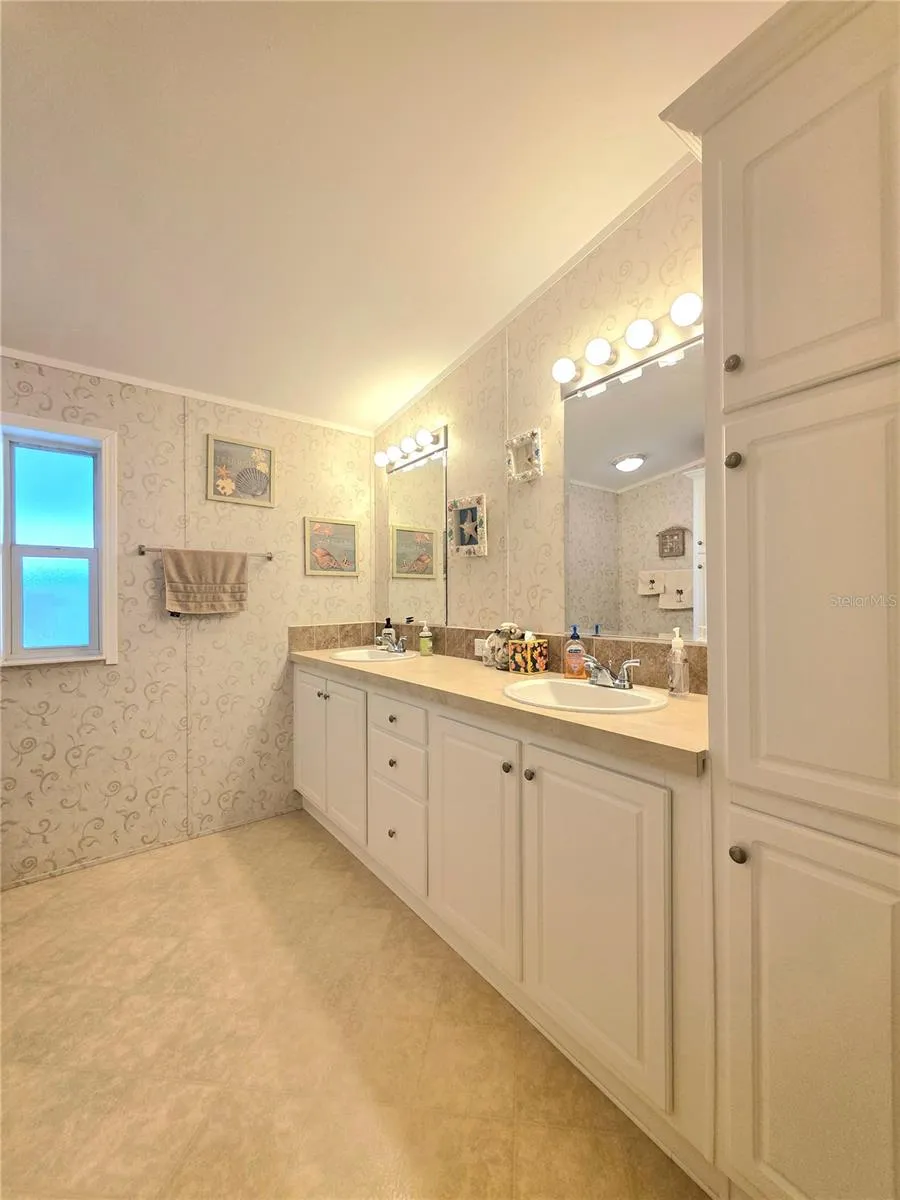 En-suite bathroom with two linen cabinets, dual sinks &amp; walk-in shower.