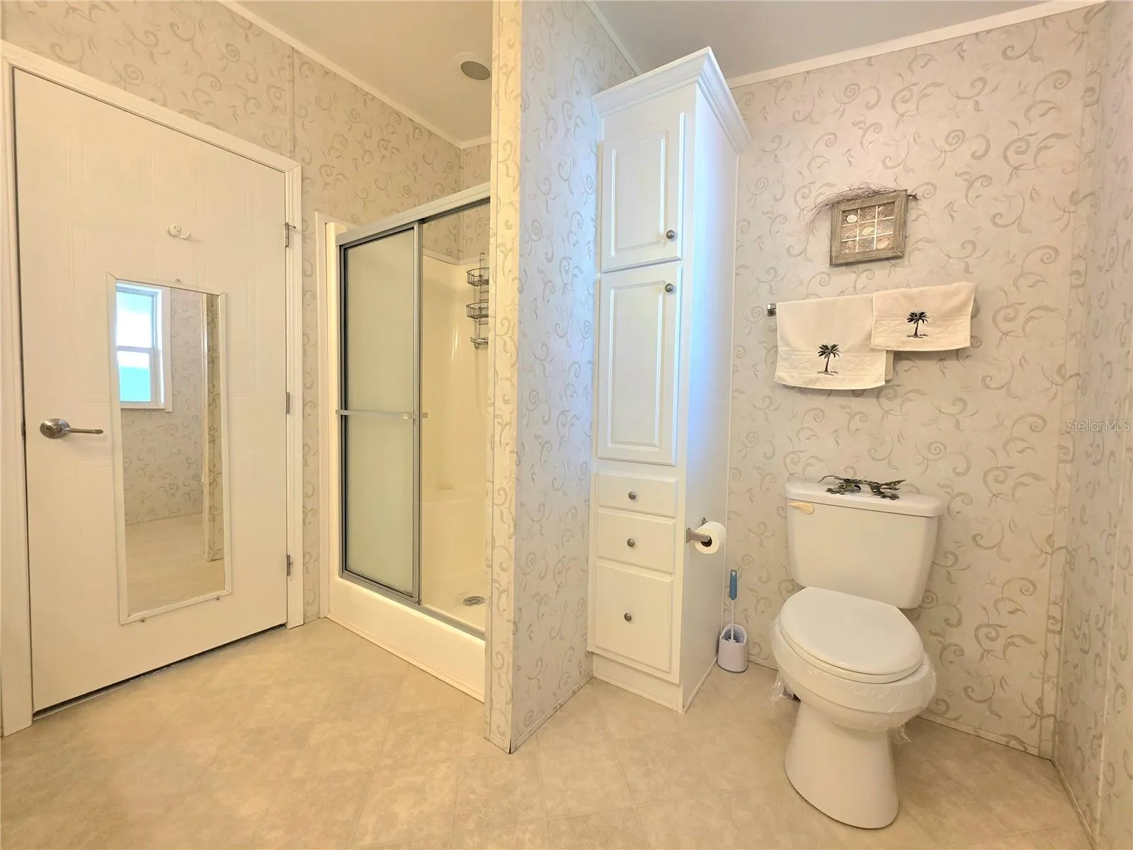 En-suite bathroom with two linen cabinets, dual sinks &amp; walk-in shower.