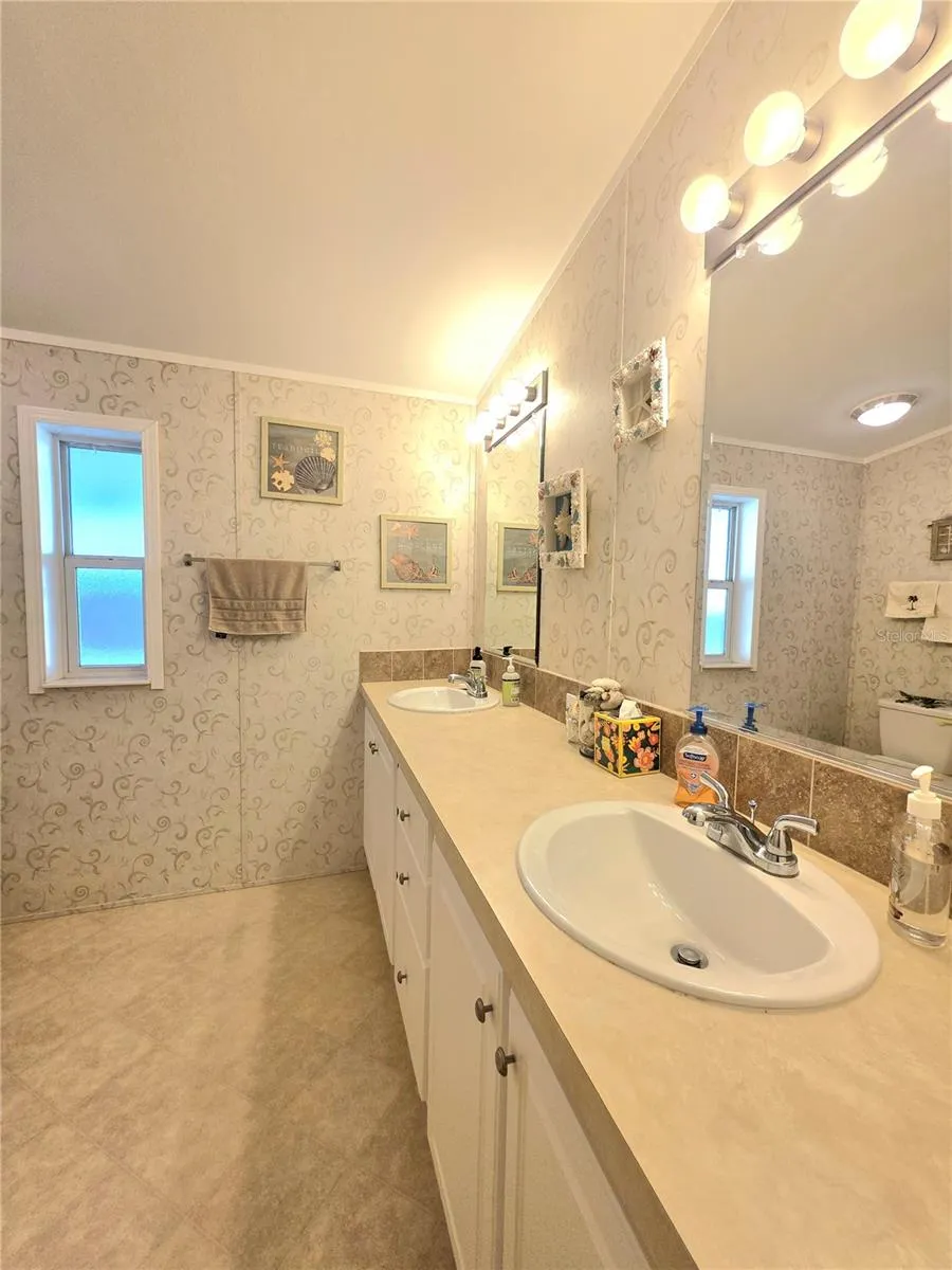 En-suite bathroom with two linen cabinets, dual sinks &amp; walk-in shower.