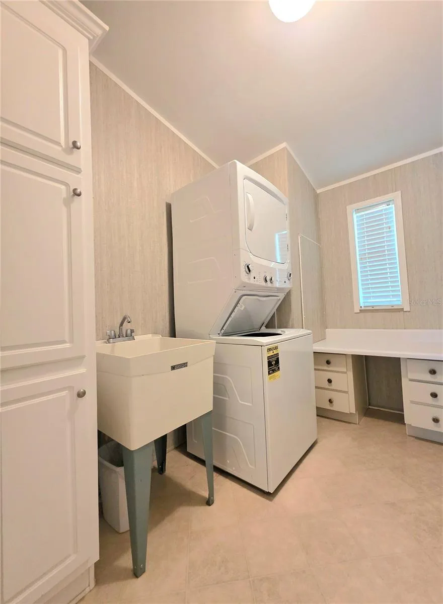 Dedicated laundry room with linen cabinet, folding table &amp; laundry tub.