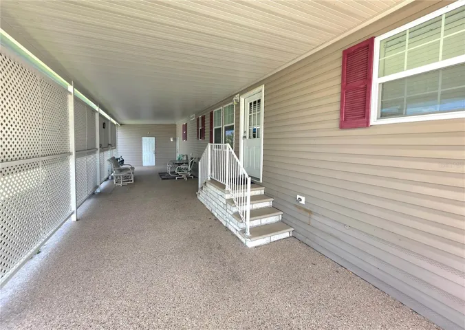Long carport with privacy lattice, shade awnings &amp; main entry door to Kitchen.