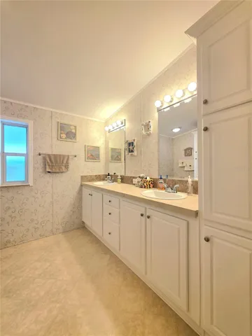En-suite bathroom with two linen cabinets, dual sinks &amp; walk-in shower.