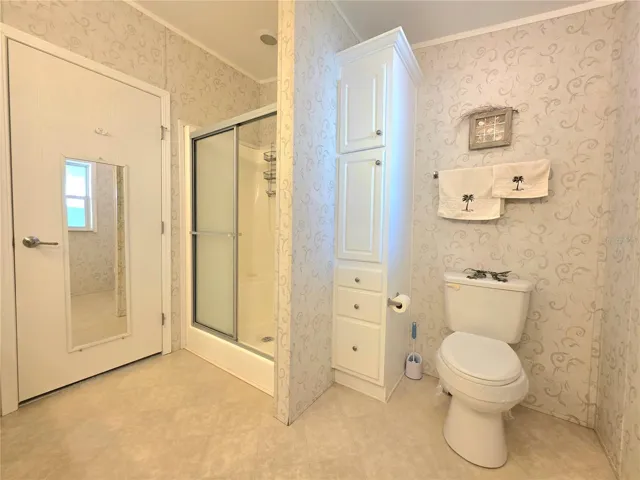 En-suite bathroom with two linen cabinets, dual sinks &amp; walk-in shower.