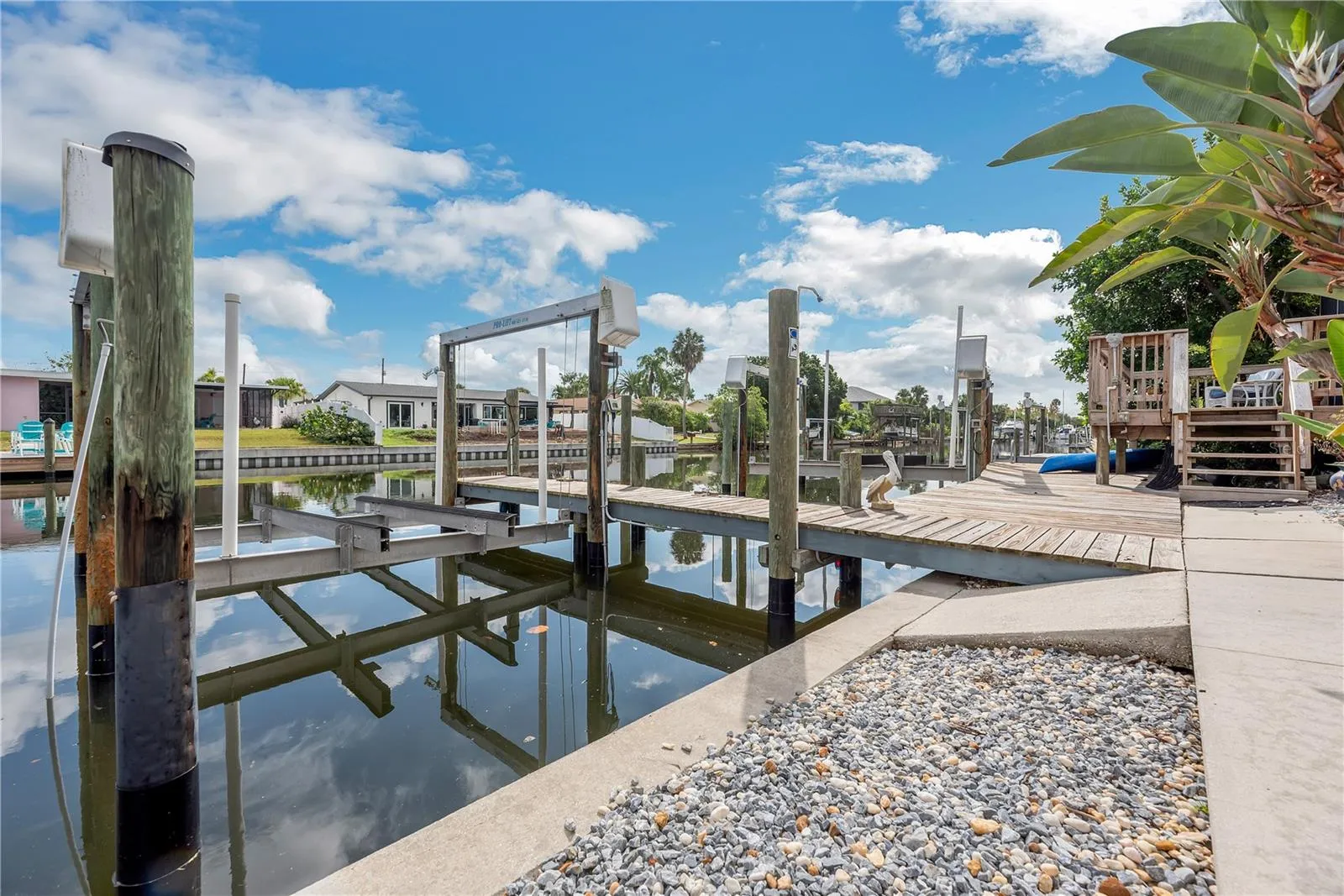 Low-maintenance stone landscaping enhances the outdoor space, while a second outdoor shower is conveniently located on the first dock piling.
