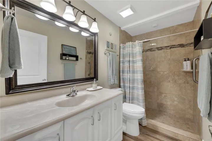 The guest bathroom has been updated with floor to ceiling tile in a spacious walk-in shower.