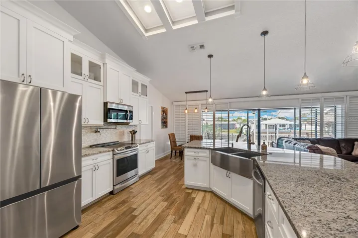 Kitchen features custom cabinetry, granite countertops, stainless steel appliances, and a spacious breakfast bar.