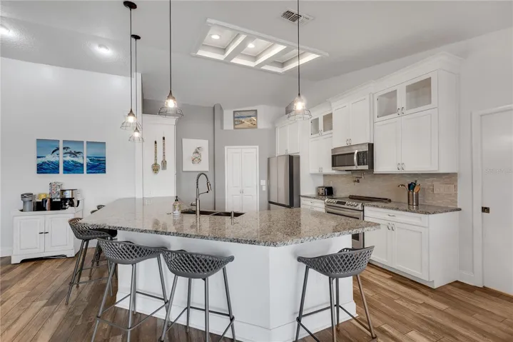 Custom cabinetry with crown molding and two glass display fronts and granite countertops set the tone for this show stopping kitchen.