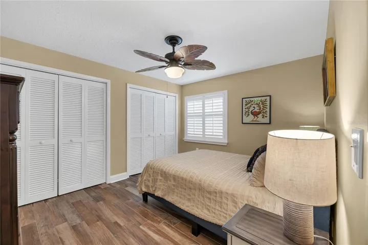 Bedroom # 3 has two built-in closets, wood-plank-look tile flooring and plantation shutters and share a hall guest bathroom.