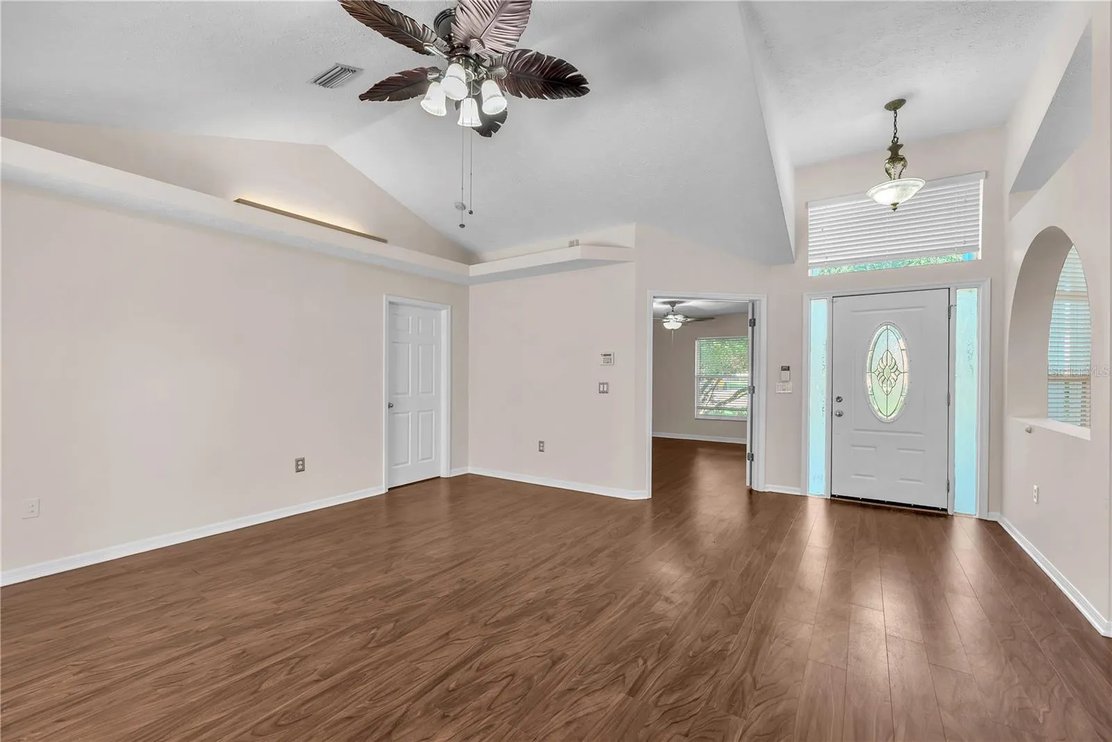 The elegant front entry features a decorative leaded-glass oval door flanked by two sidelights and topped with a transom window, allowing beautiful natural light to fill the foyer and create a warm, inviting welcome.