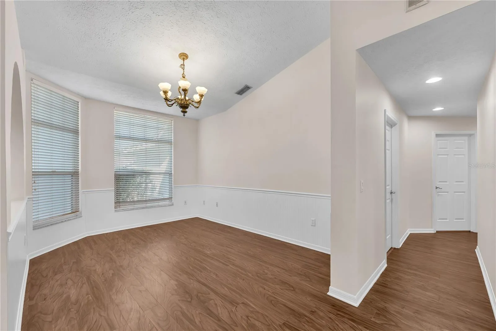 The dining room is conveniently located just off the kitchen and features charming shiplap wainscoting with a classic chair rail, adding texture and character to the space.