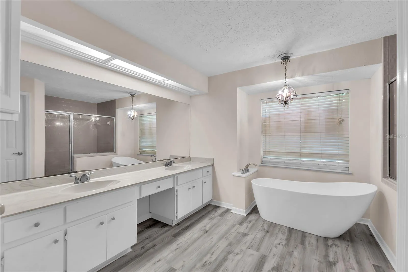 The owner's ensuite bath has a large vanity with dual sinks and plenty of storage, an elegant freestanding slipper tub, separate shower, and private water closet.