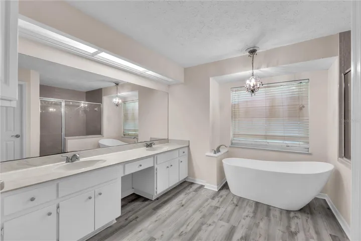 The owner's ensuite bath has a large vanity with dual sinks and plenty of storage, an elegant freestanding slipper tub, separate shower, and private water closet.