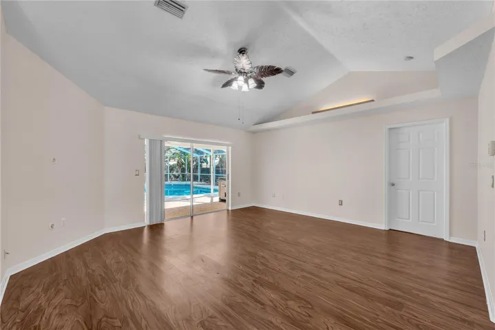 As you enter the living room, your eye is naturally drawn through the space to the sparkling pool and inviting backyard beyond, creating an immediate sense of openness and Florida-style indoor-outdoor living.