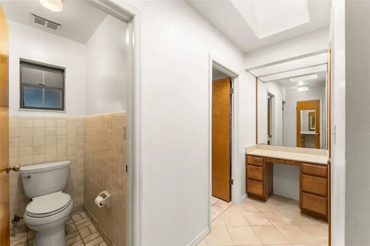 Primary bathroom with commode room and makeup area