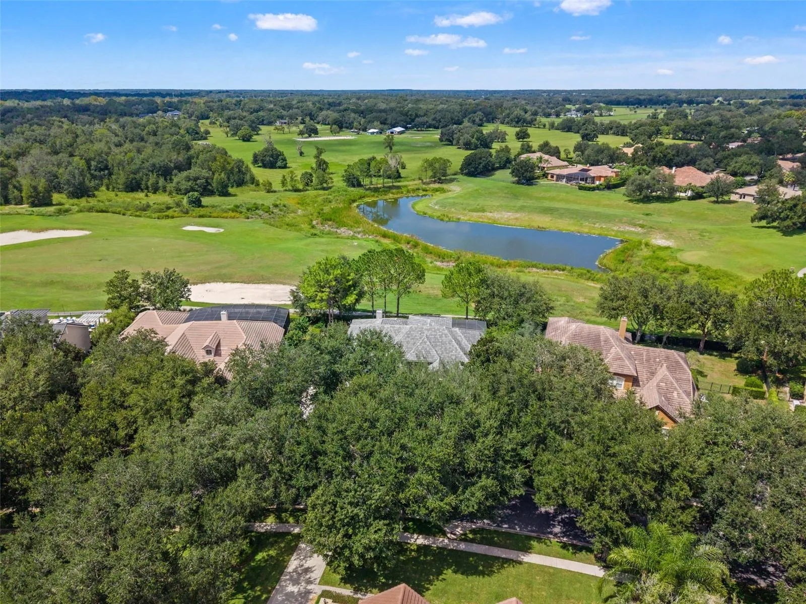 House looking over the golf course, pond, and horse pastures in the distance
