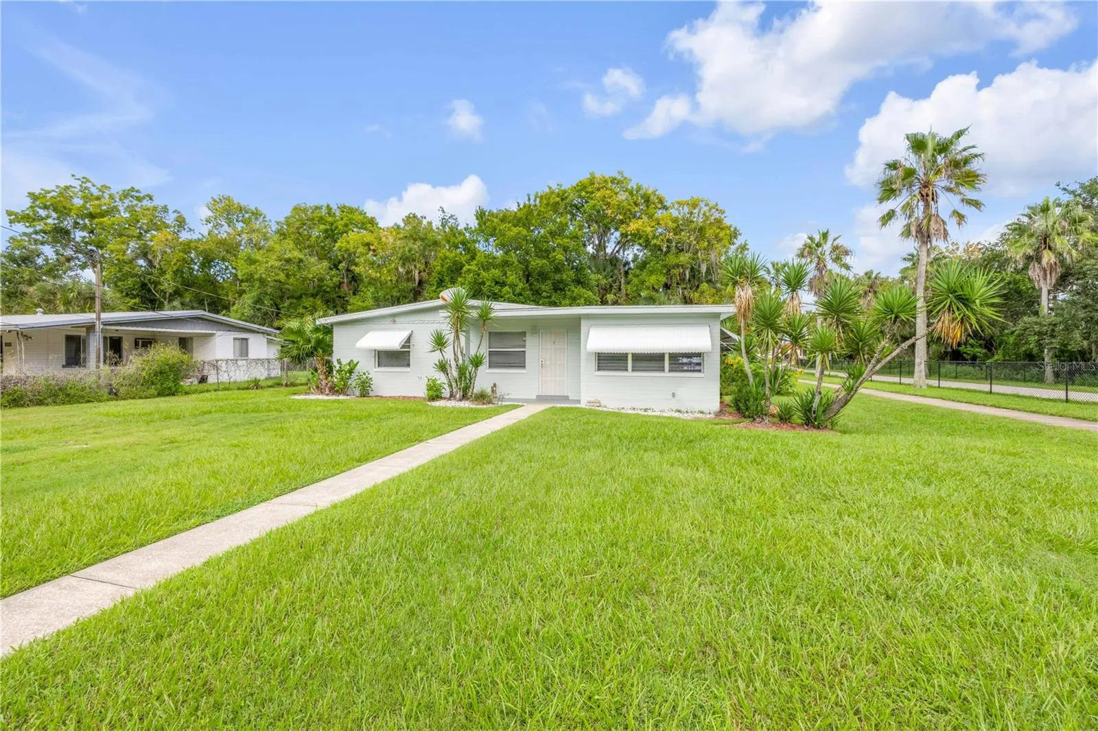 Ariel- Front of property looking East- View 1- Beautiful spacious Front space- Corner lot