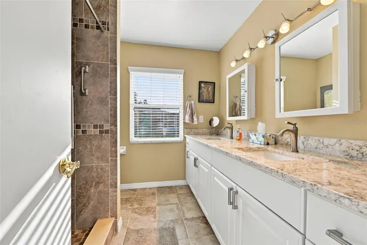 Guest bathroom is updated and modern with dual sinks, cabinetry and lovely tile work.