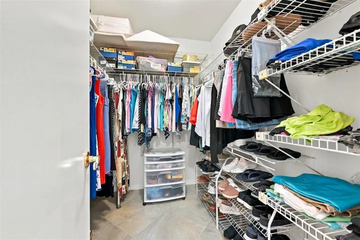 Large walk-in closet with lots of shelving for storage.