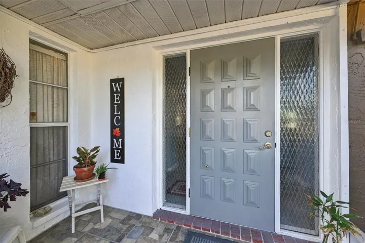 Screened front porch is and excellent area for plants and guests to get out of the weather.
