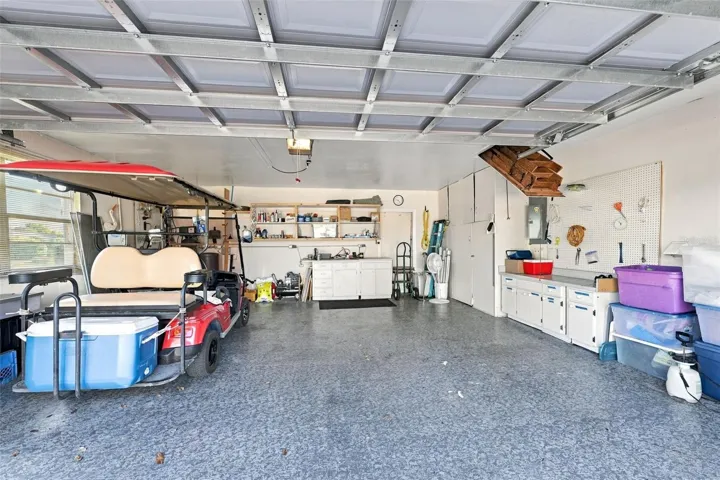 The garage is oversized, with epoxy flooring, storage cabinets and YES, the golf cart is included. Notice the attic stairs offer full storage capability, if desired.