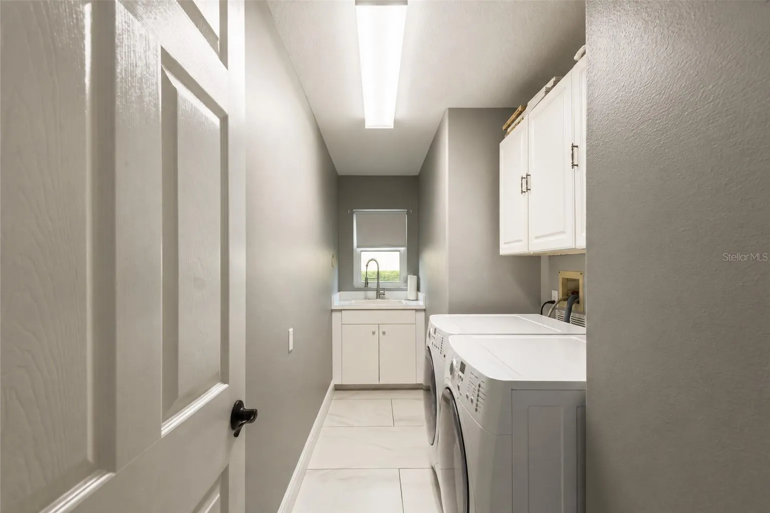 Laundry room with storage and sink.